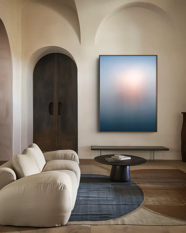 Echoes of Light 05 als gerahmtes Wandbild in einem Raum im Japandi-Stil – kühle Blau- und Grautöne mit warmem Lichtbereich in Rosé und Apricot.
